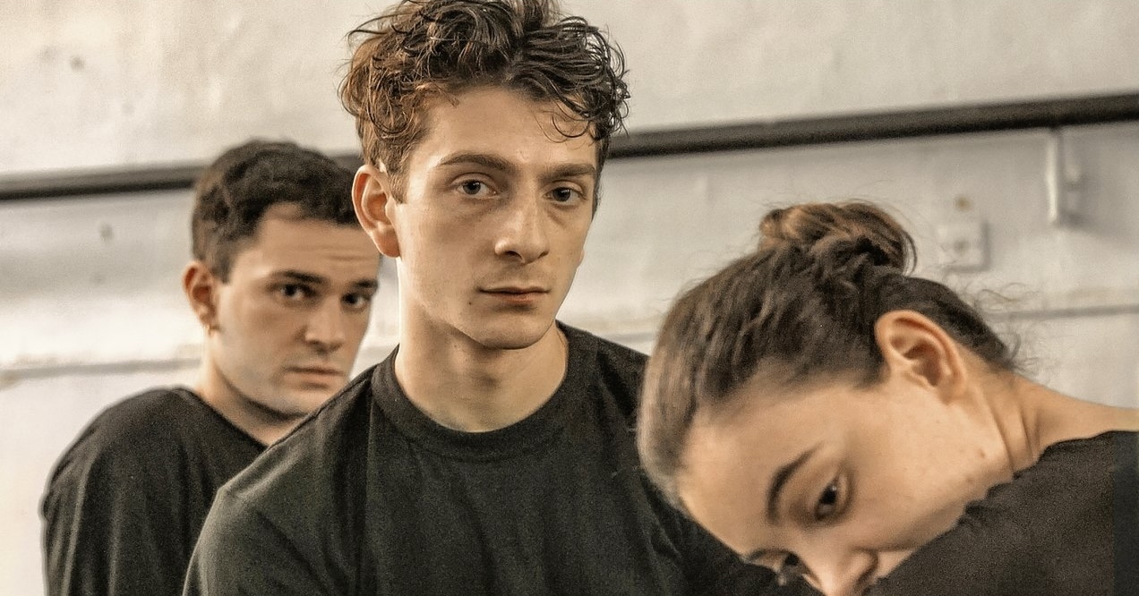 Drie dansers uit de film kijken in de camera.