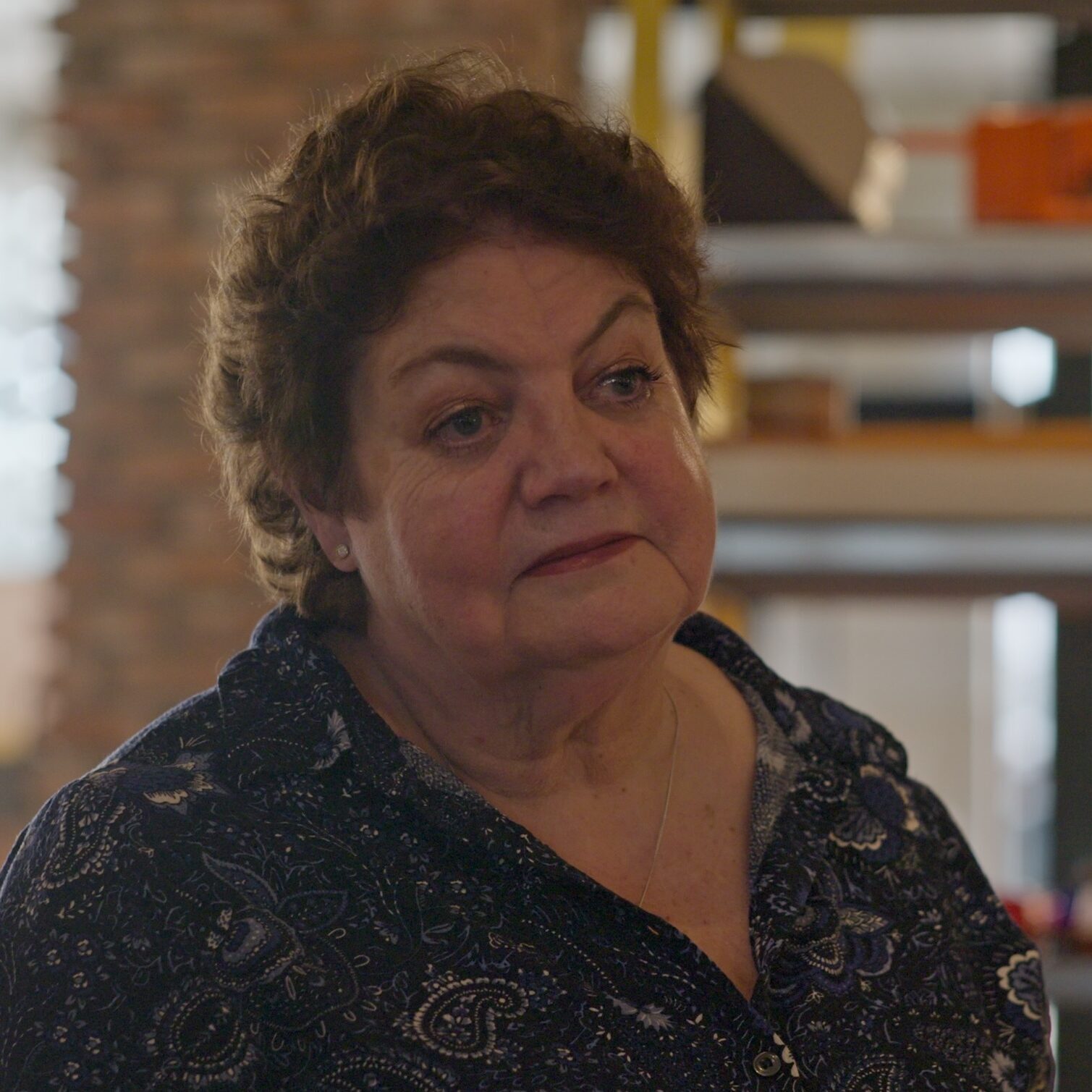 Een mevrouw uit de documentaire 'Dit hoort bij ons' kijkt moedeloos voor zich uit.