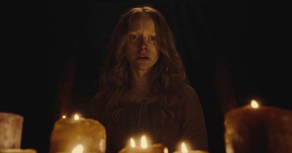 Vrouw kijkt angstig boven kaarsen