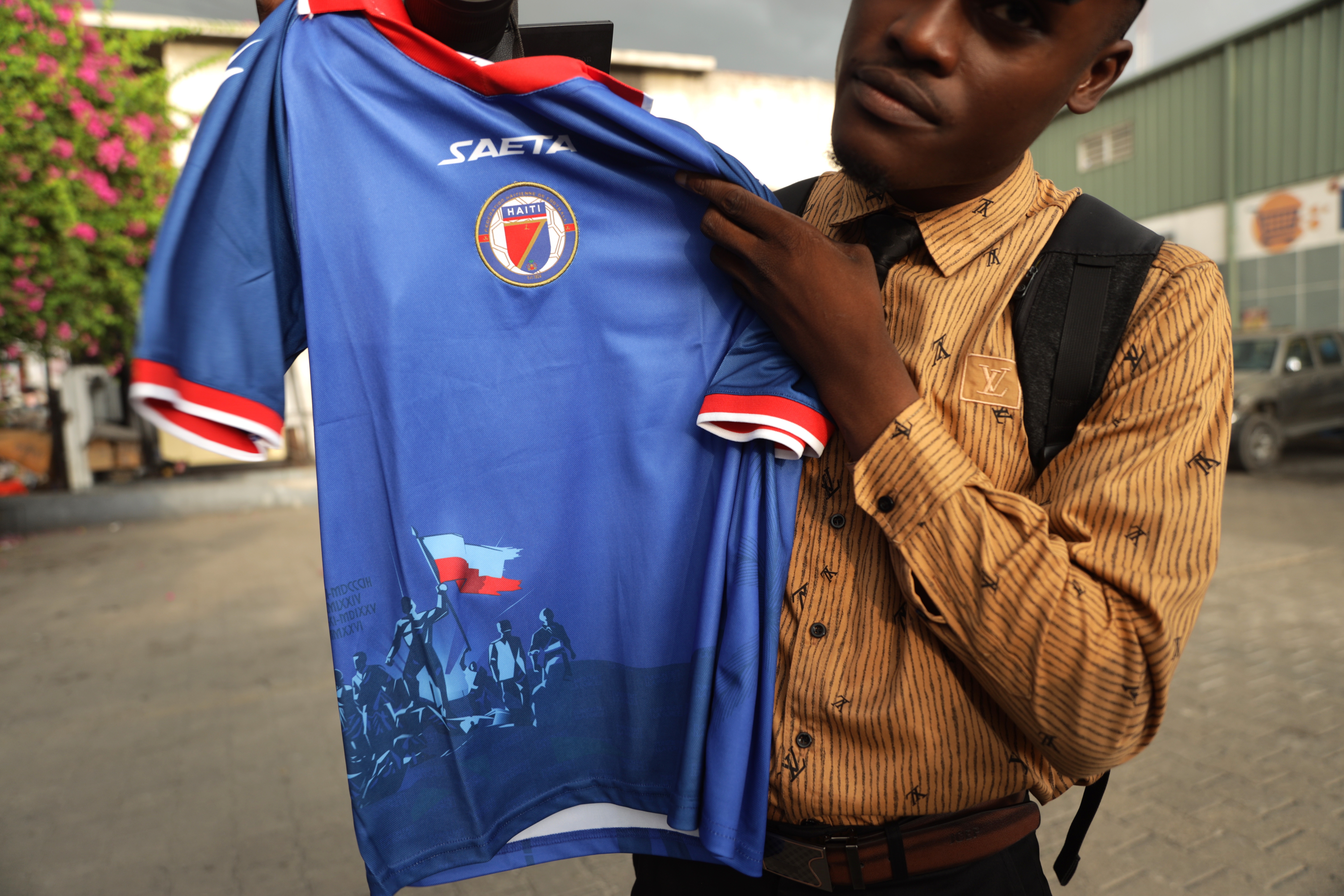 epa13029595 A person holds up a Haiti national soccer team jersey in Port-au-Prince, Haiti, 10 June 2026. Colombian sportswear manufacturer Saeta said it changed the design of the jersey Haiti will wear at the FIFA World Cup 2026 after FIFA objected to certain visual elements on the uniform.  EPA/PATRICE NOEL