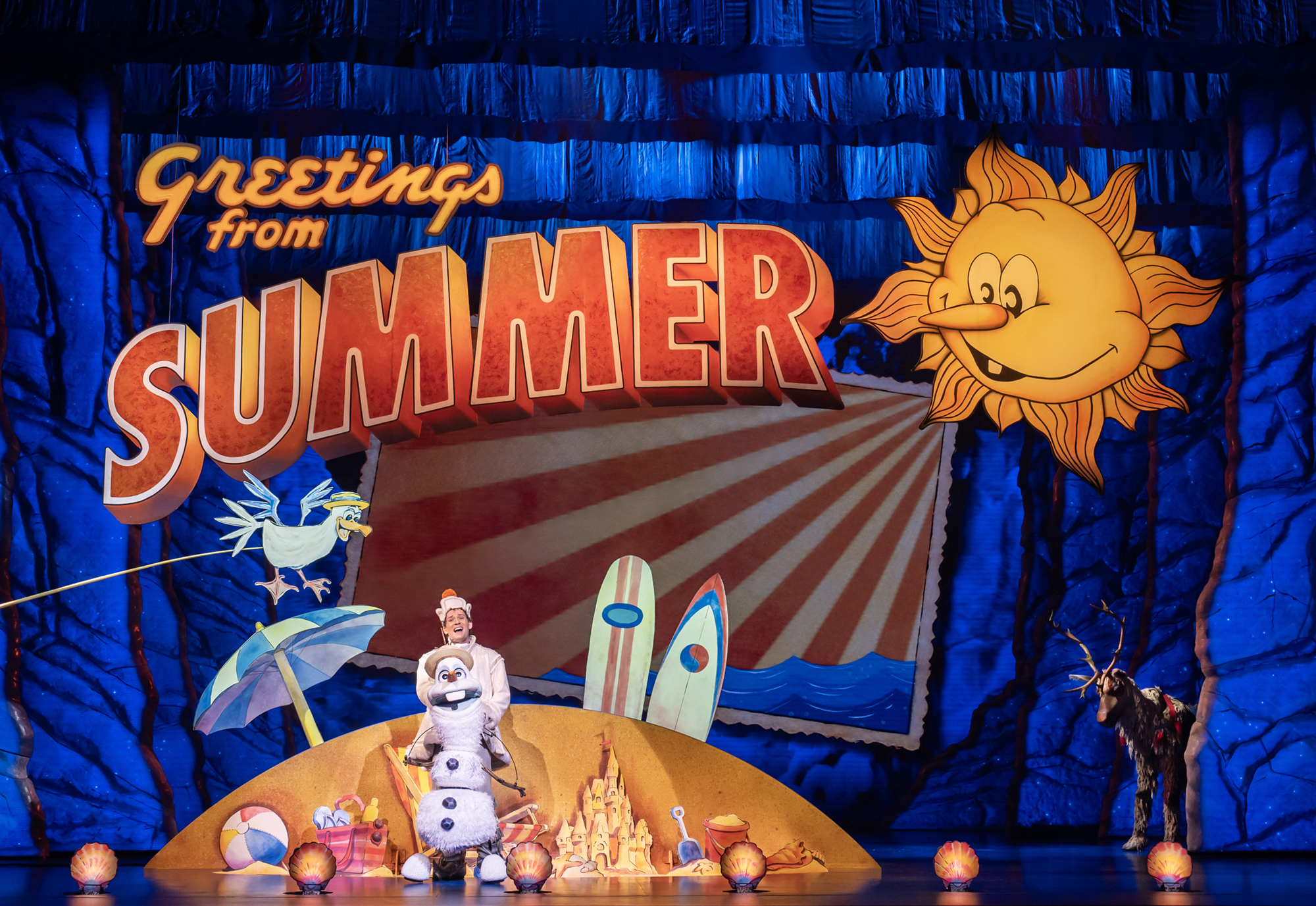 Je ziet een acteur in een sneeuwpop-pak voor een decor met ...