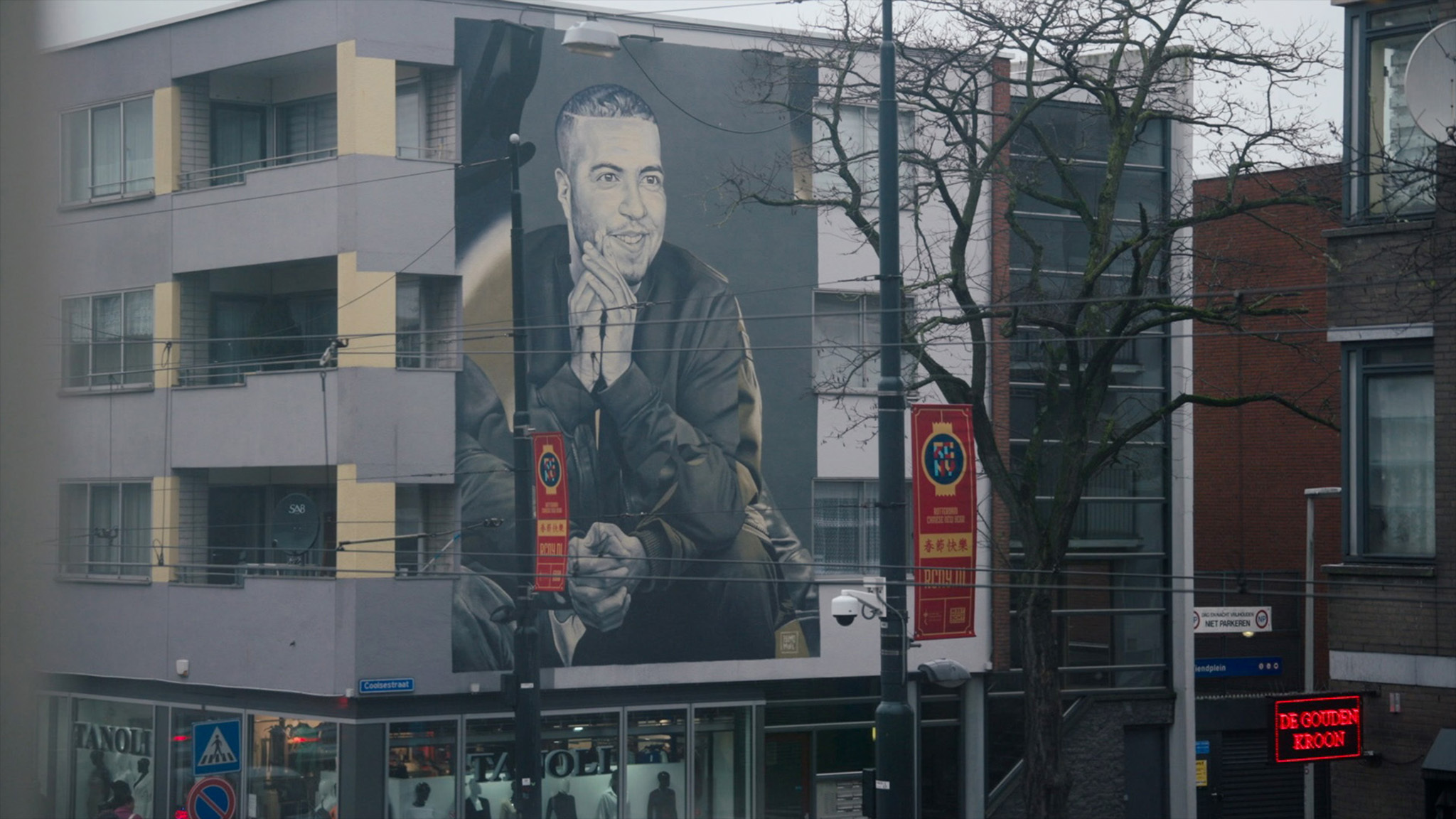 Muurschildering van rapper Feis op de zijkant van een pand in Rotterdam.