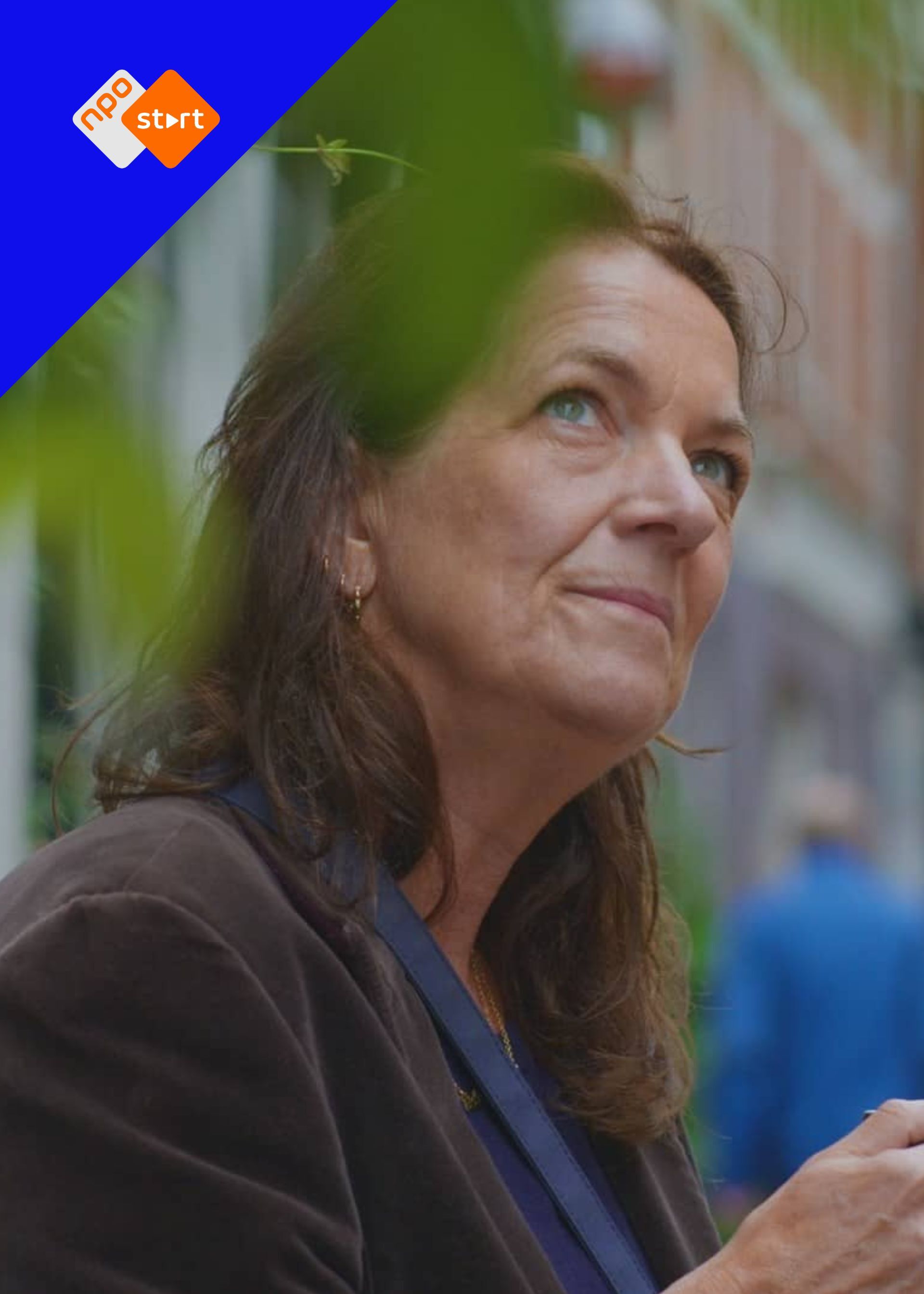 Witte vrouw met bruine haren en blauwe ogen kijkt in gedachte naar boven