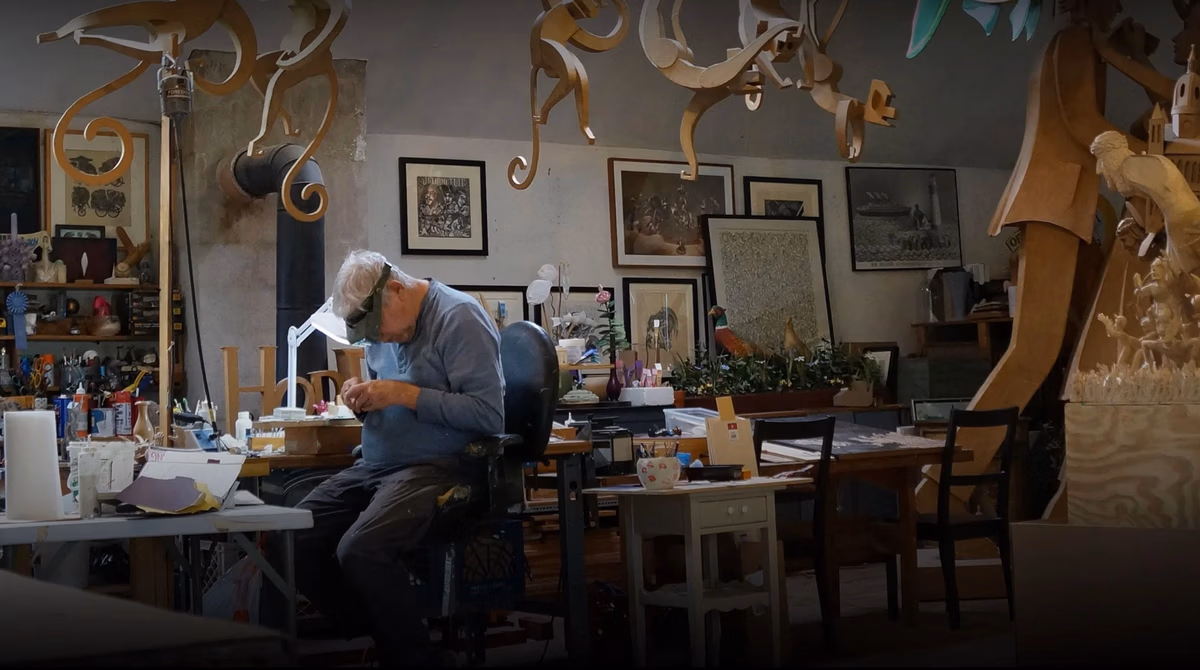 Jimmy Grashow bezig in zijn atelier. Om hem heen hangen allerlei onderdelen van zijn kunstwerken.