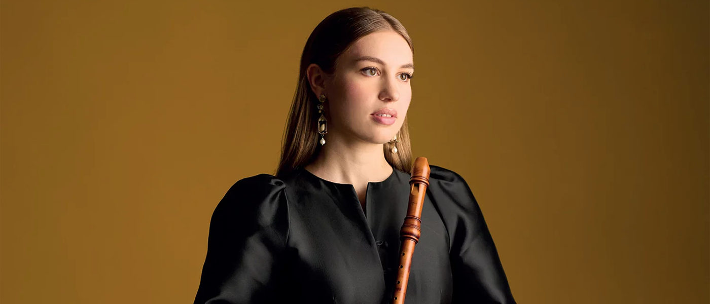 Muzikant Lucie Horsch in een zwarte blouse met een blokfluit in haar hand.