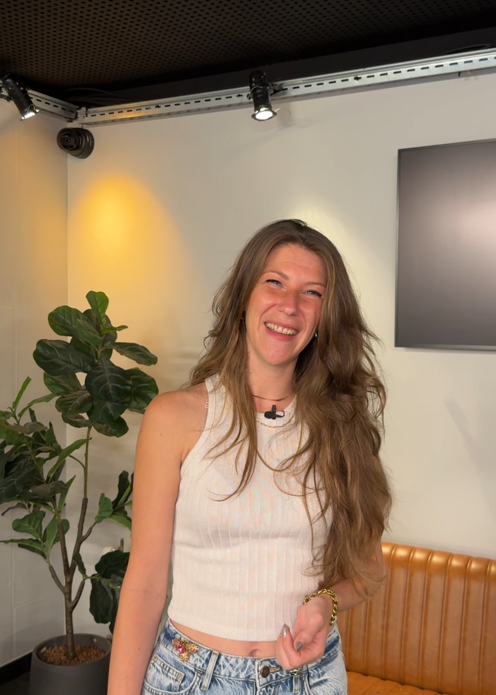 Foto van Nikki, waar dit artikel over gaat. Ze kijkt lachend de camera in. Zee heeft lang haar wat ze los draagt.