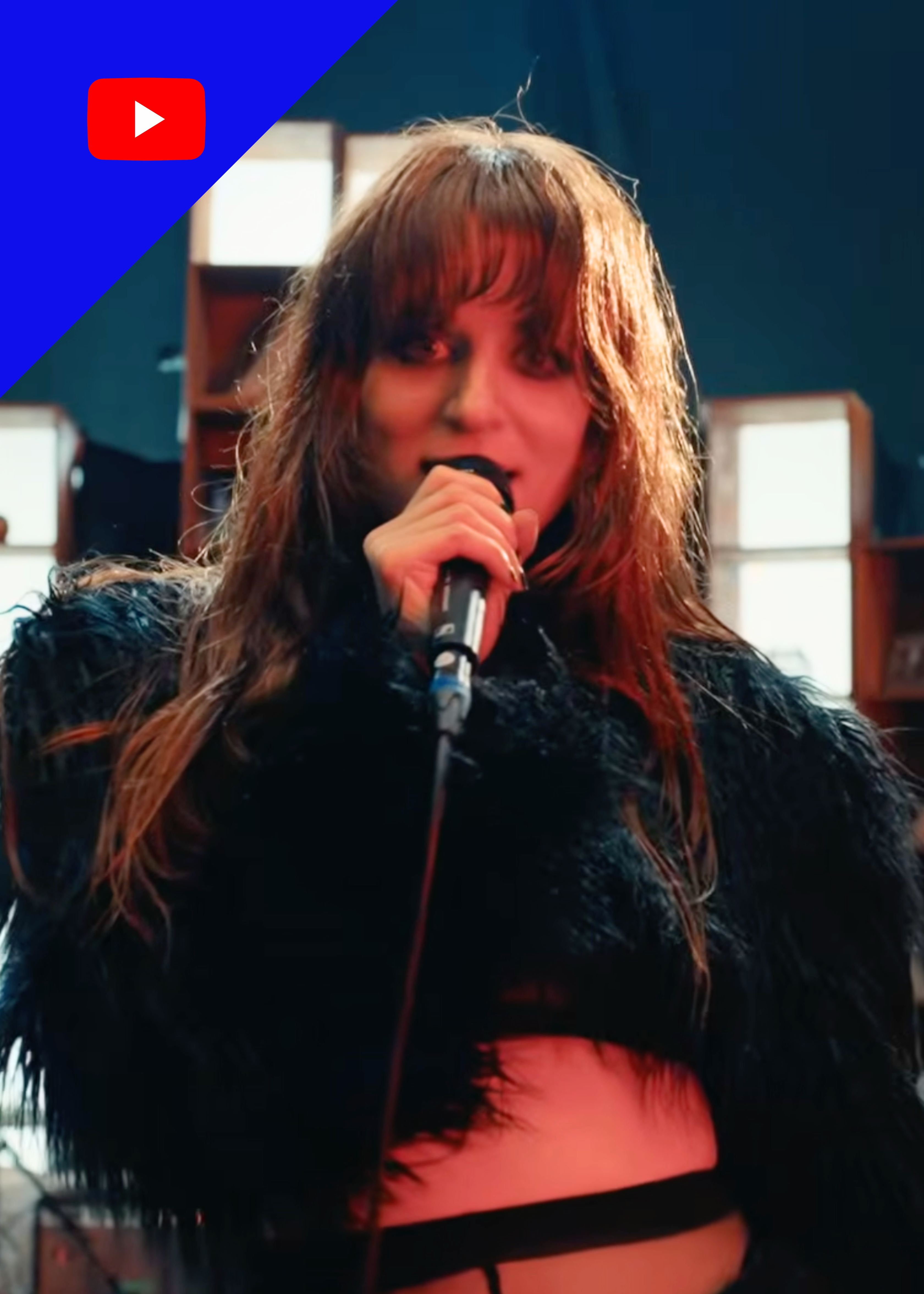 Zangeres MEROL zingt in zwart harige outfit en kijk recht in de camera