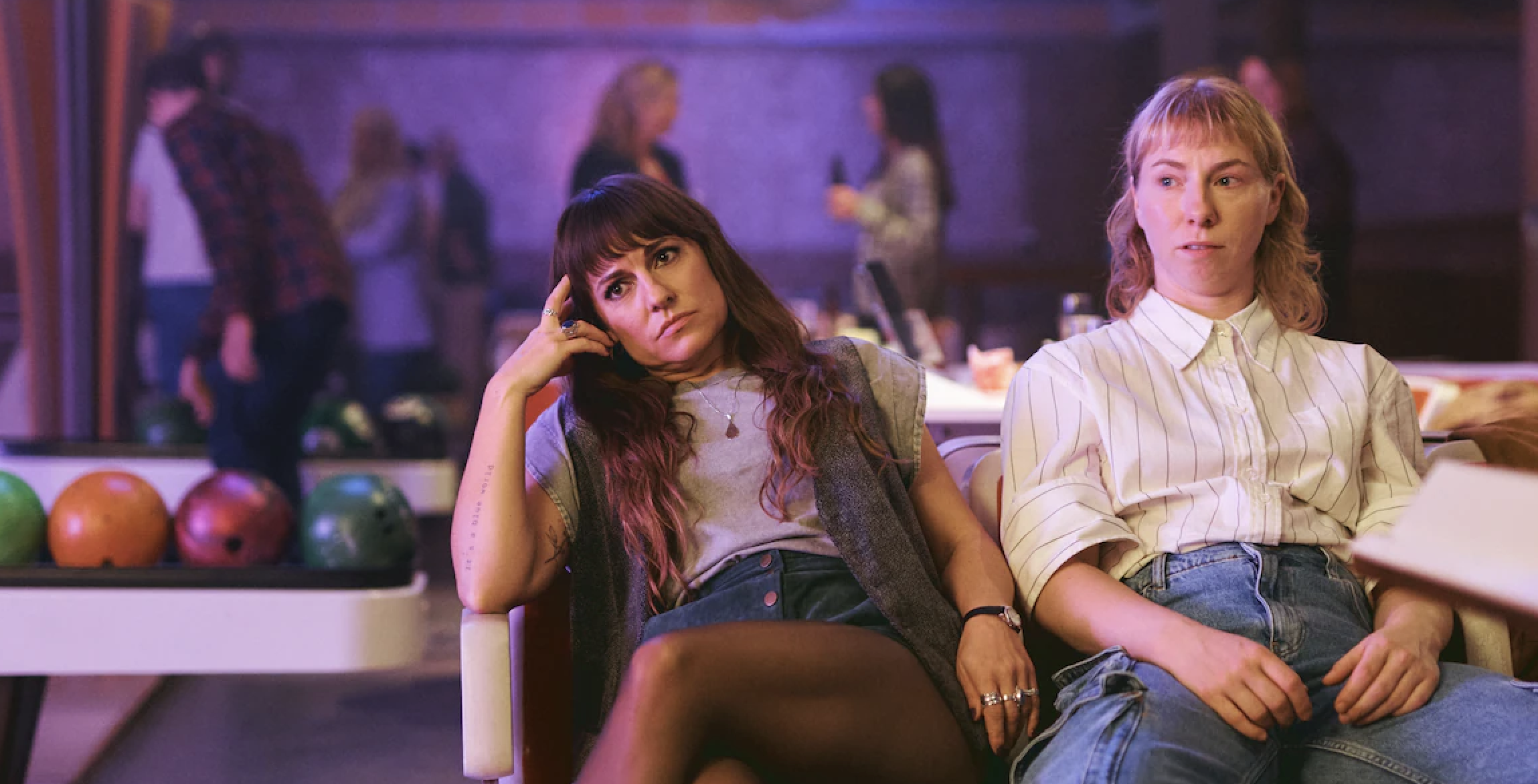 Twee zussen zitten verveeld bij een bowlingbaan