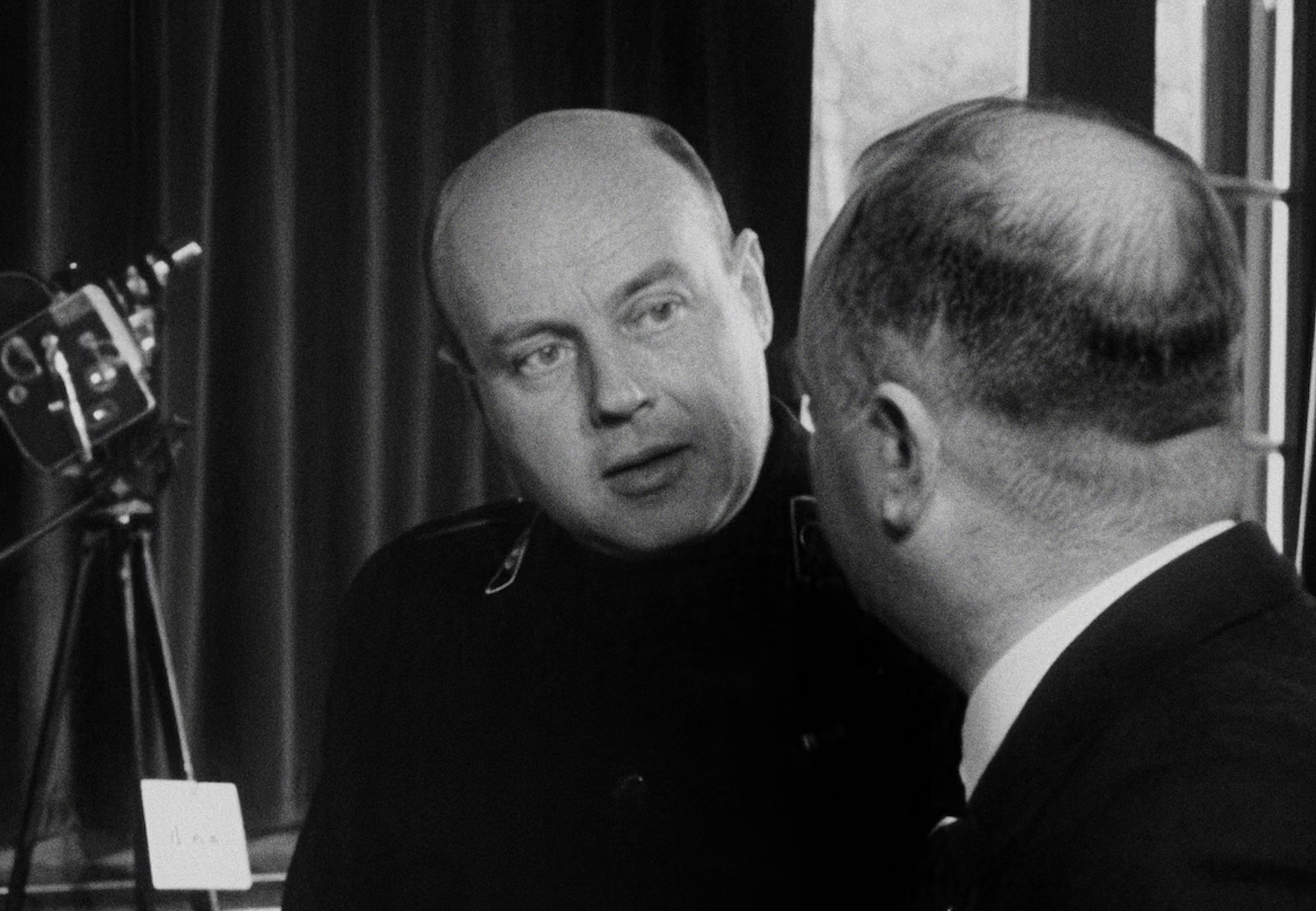 Jan Theunissen heeft een camera vast en praat met een kale heer