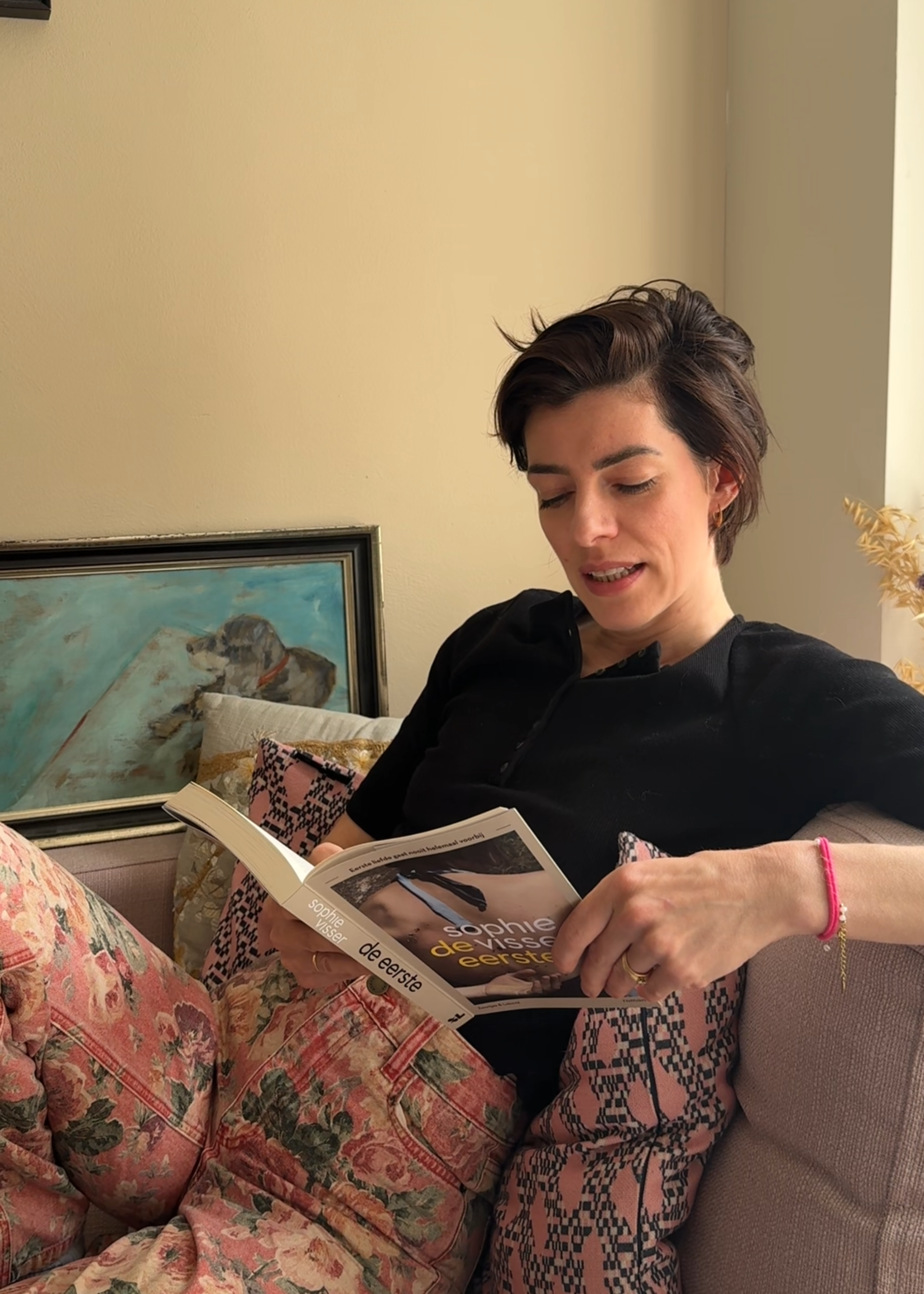 Sophie de schrijfster zit op de bank en leest voor.