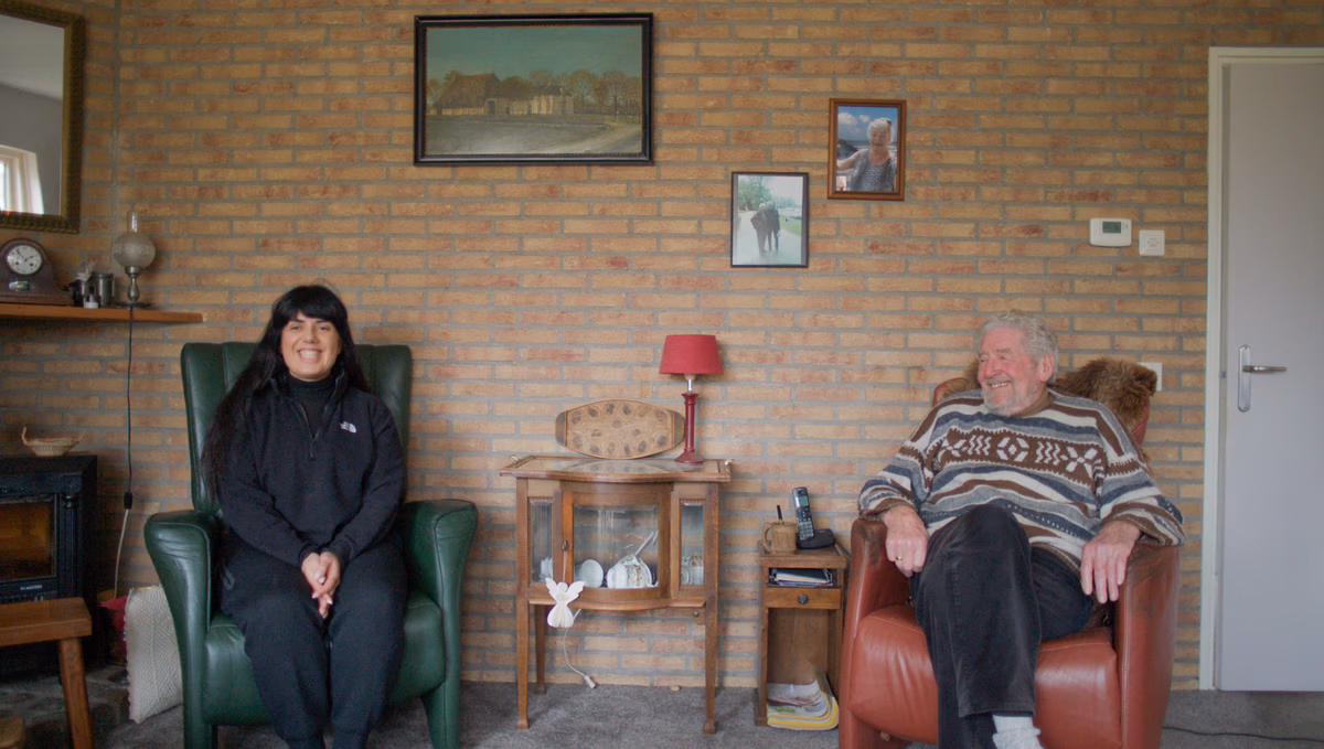 Friese man en Iraanse vrouw zitten samen in een woonkamer op 2 leesstoelen