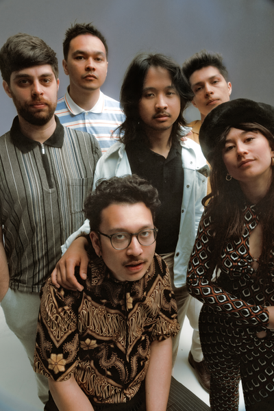 Band Nusantara Beat, bestaande uit zes leden (één vrouw en zes mannen), kijkt in fish eye-lens.