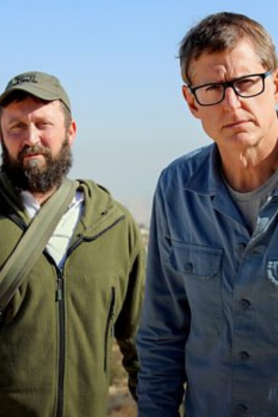 Louis Theroux met een man in een groene trui.