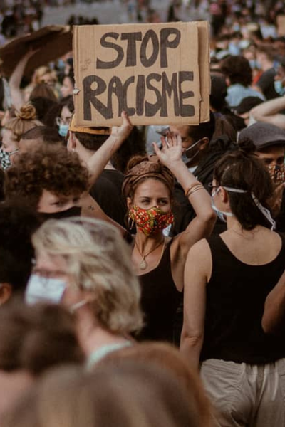 Vrouw houdt bord op tijdens demo: Stop racisme