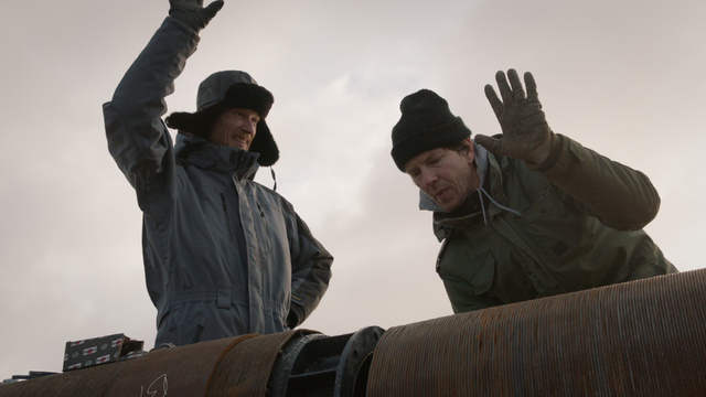 Twee broers die hun handen omhoog houden bij een buis