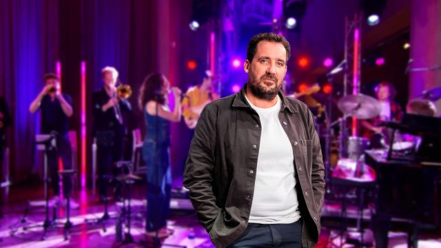 Gijs Groenteman in De Lichtfabriek met op de achtergrond een band