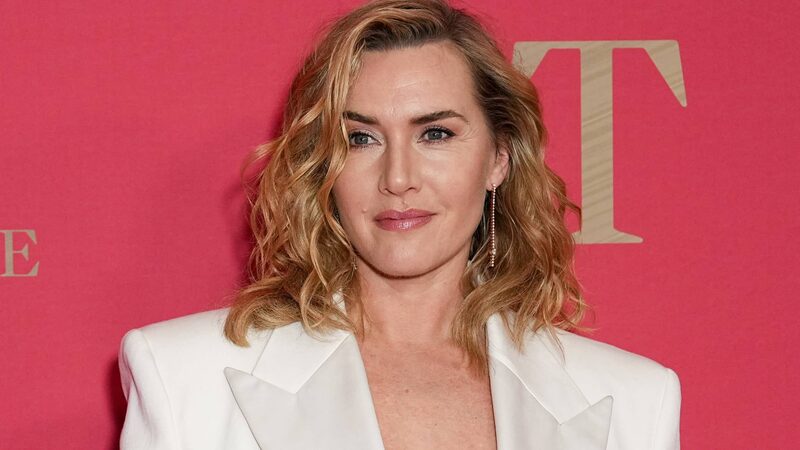 Actrice Kate Winslet staat voor een roze muur geposeerd