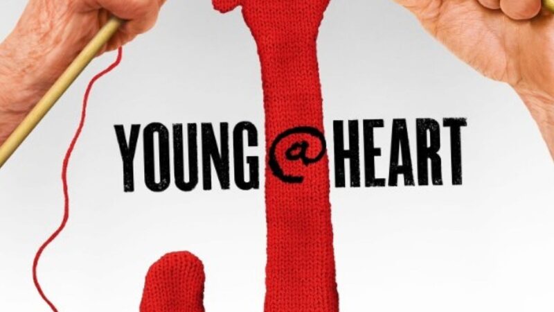 Cover van de documentaire Young@heart. Twee handen breien een rode gitaar. Daaronder staan de koorleden.