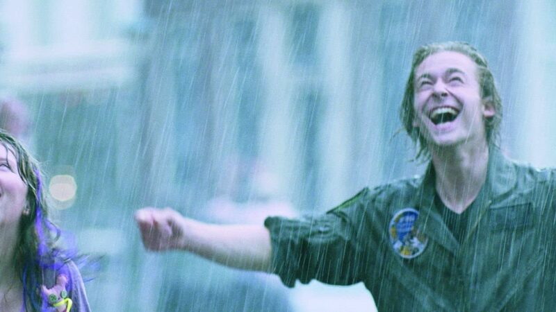 Twee mensen staan dolgelukkig in de regen