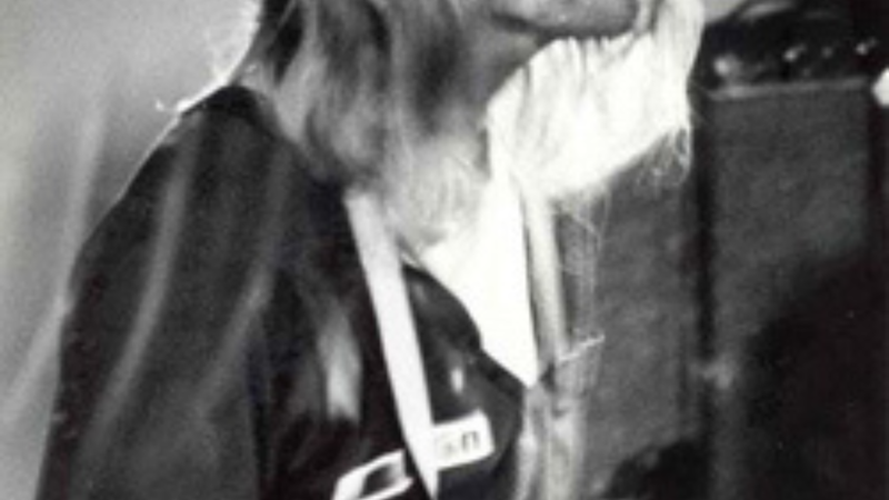 Foto van Kurt Cobain van Nirvana in VERA. Het is een zwart wit foto van een man met lang blond haar en een gitaar in zijn handen. De foto is van erg dichtbij gemaakt.