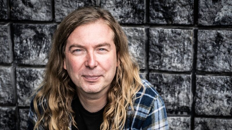 Luuk Bouwman kijkt de camera in met zwarte tegels op de achtergrond