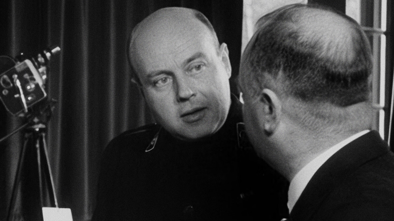 Jan Theunissen heeft een camera vast en praat met een kale heer