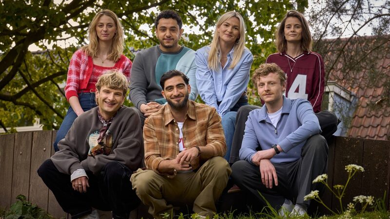De personages van dertigers poseren buiten in een tuin