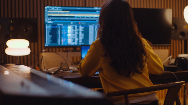 Vrouwelijke producer aan het werk achter haar bureau.