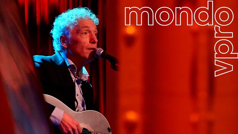 Spinvis zingt met een rode gitaar met een rode achtergrond