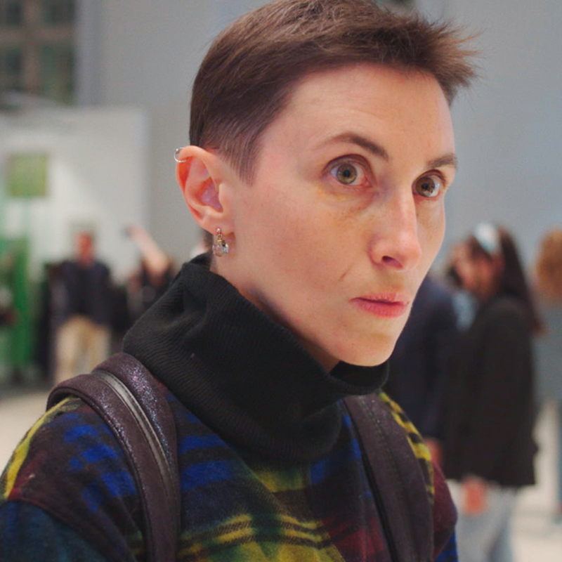 Vrouw op een kunstbeurs kijkt naar iets dat buiten beeld gebeurt