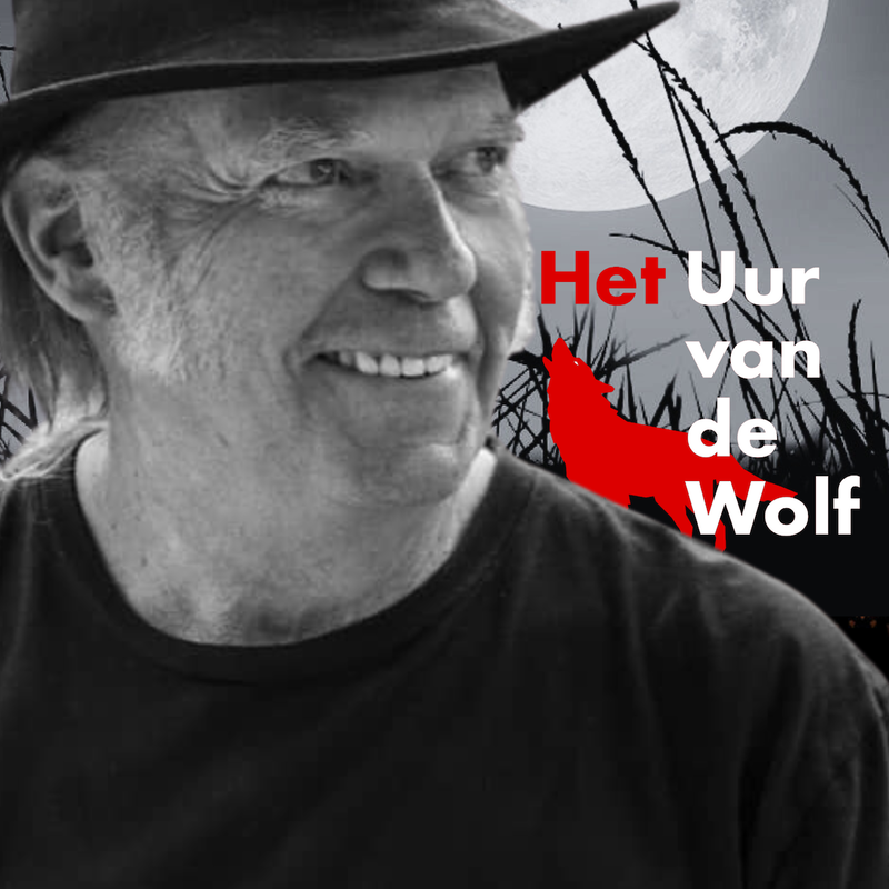 Neil Young kijkt lachend opzij en draagt een hoed.