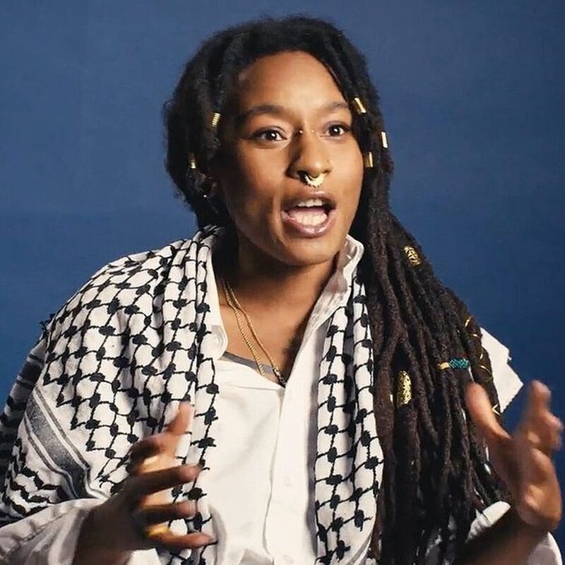 Naomi Pieter wordt geïnterviewd en spreekt bevlogen met een Palestijnse sjaal om