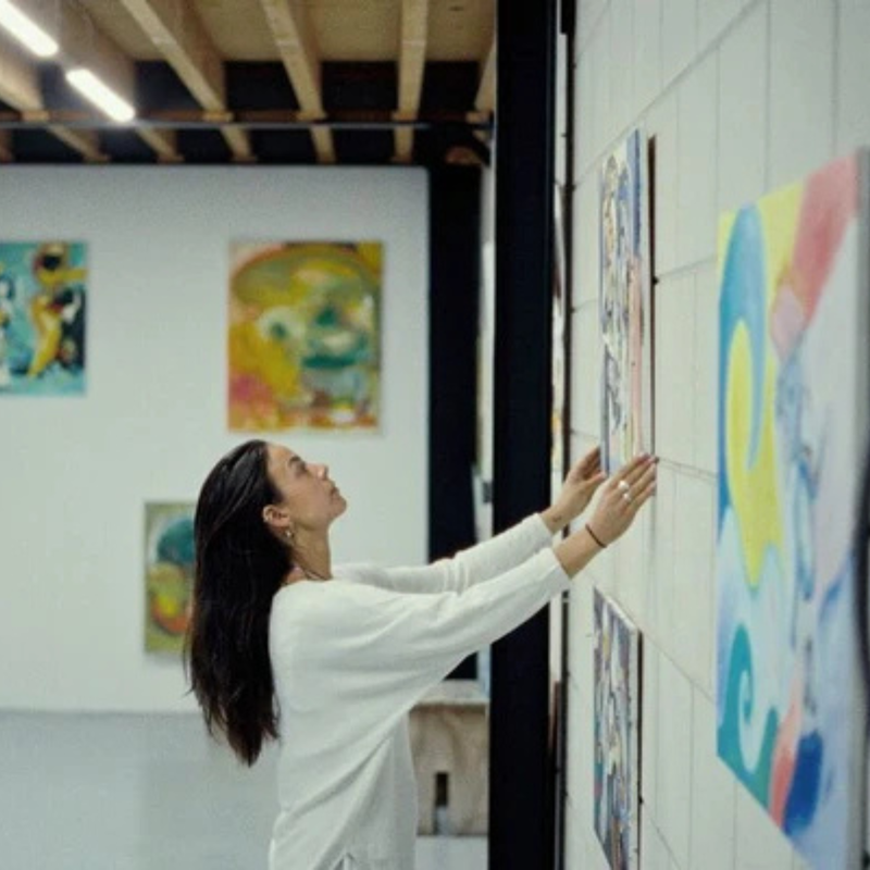 Vrouw hangt schilderij op in loods