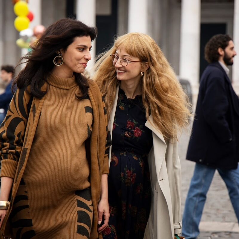 De vriendinnen lopen lachend over straat.