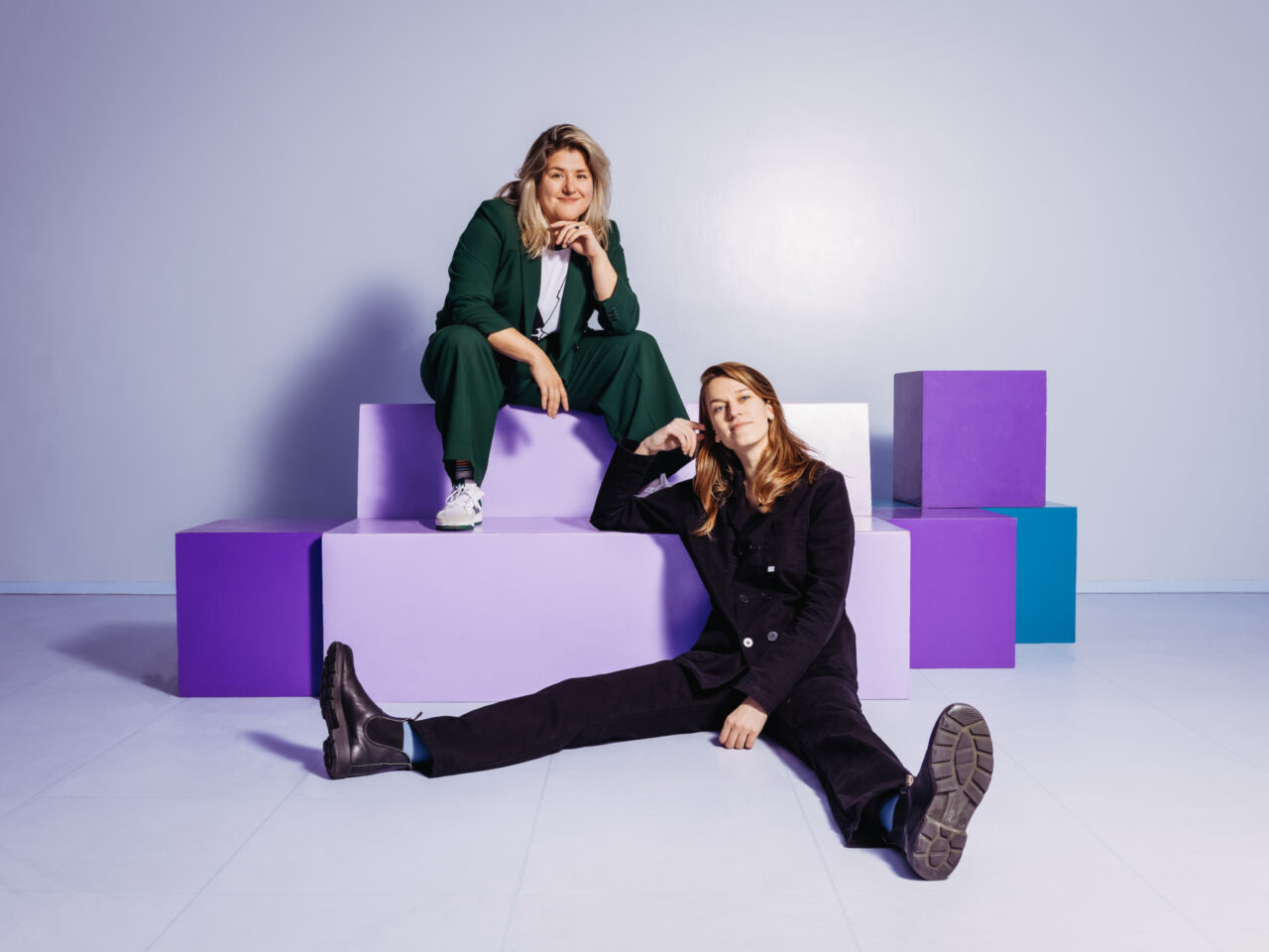 Annefleur en Vera zitten speels op en voor grote paarse blokken