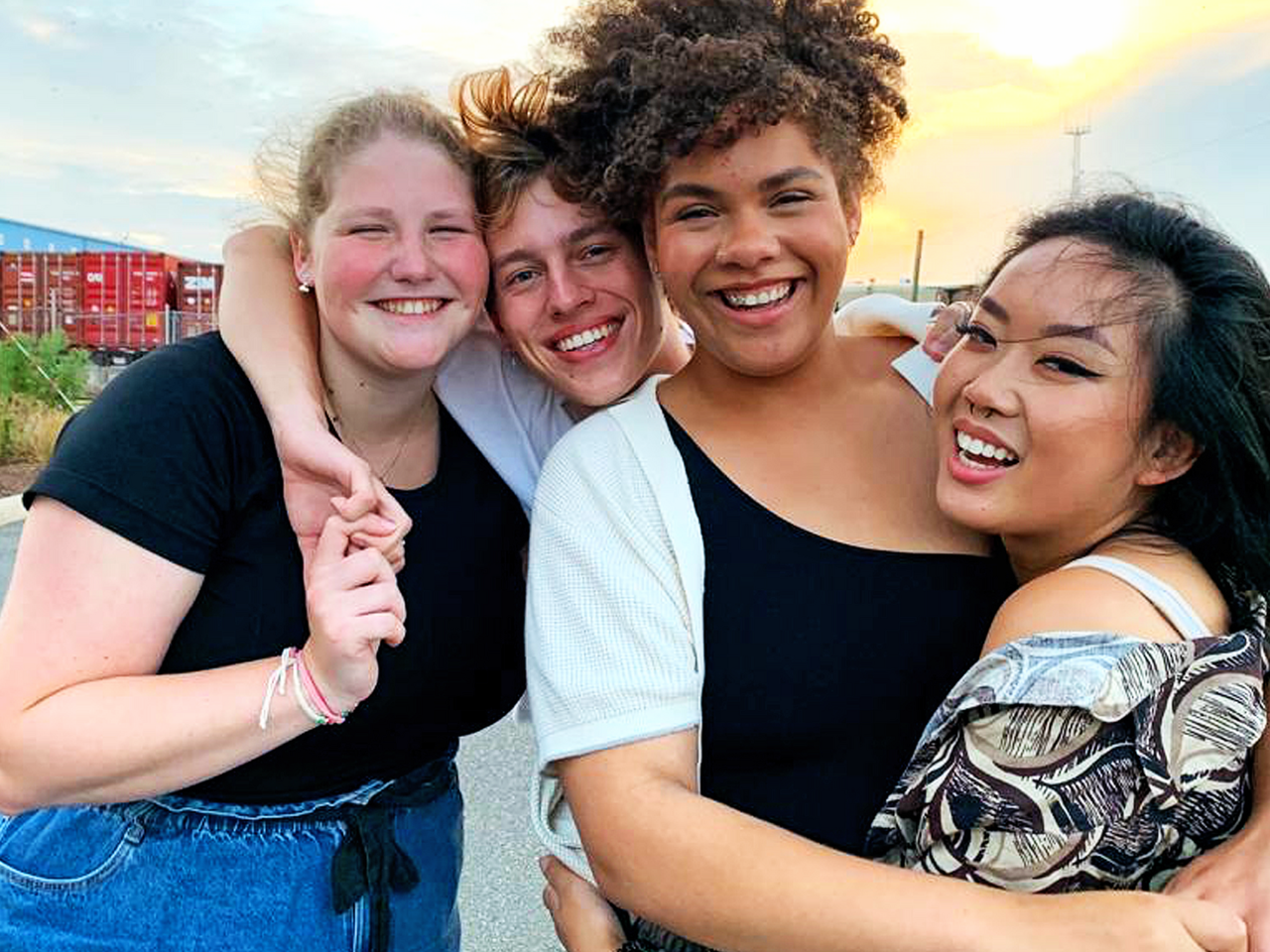 Anne, Bram, Jaimy en Sincha lachen naar de camera en omhelzen elkaar