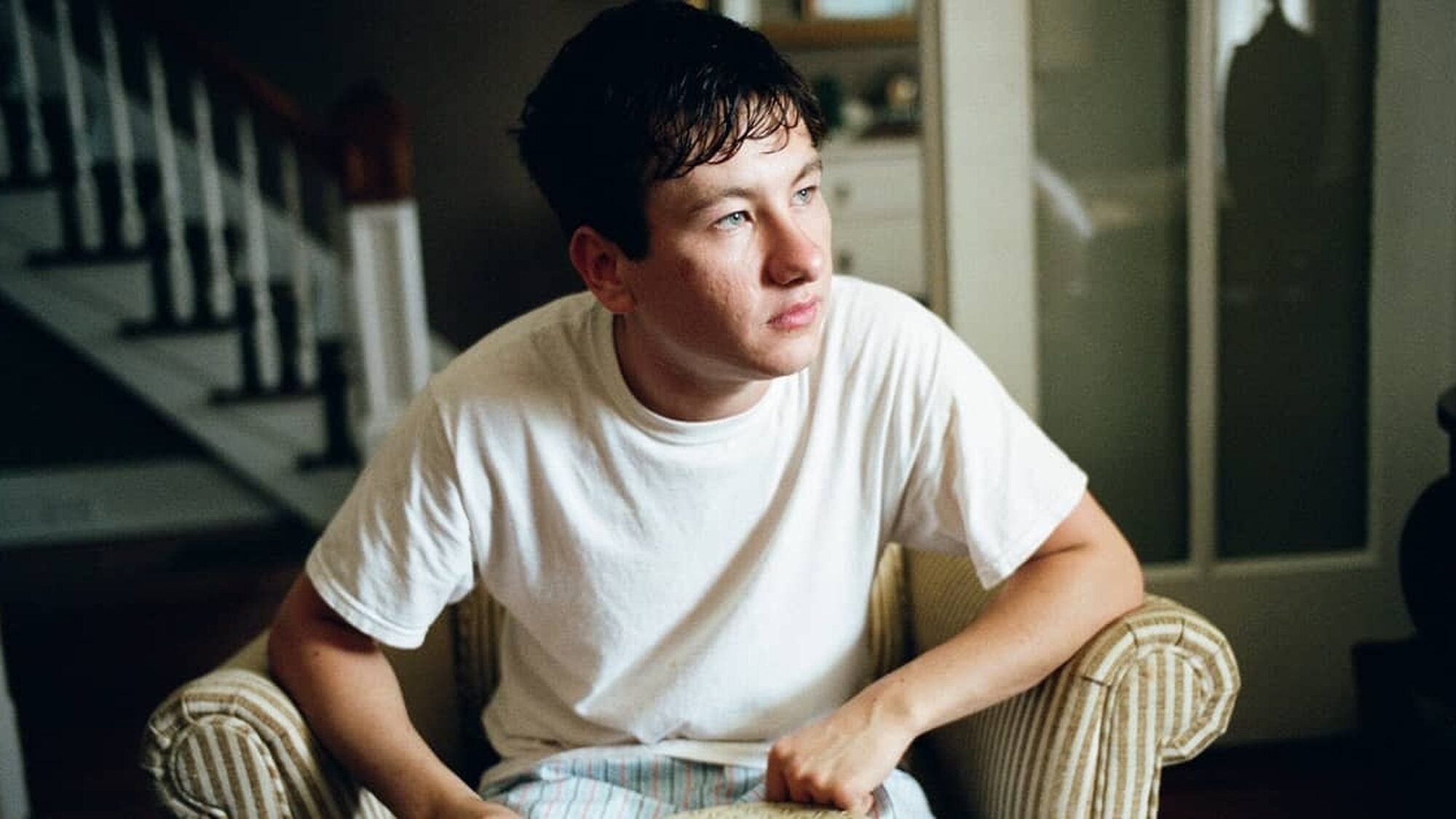 Een personage uit de film The Killing of a Sacred Deer zit op een fauteuil en kijkt naar een punt buiten de camera