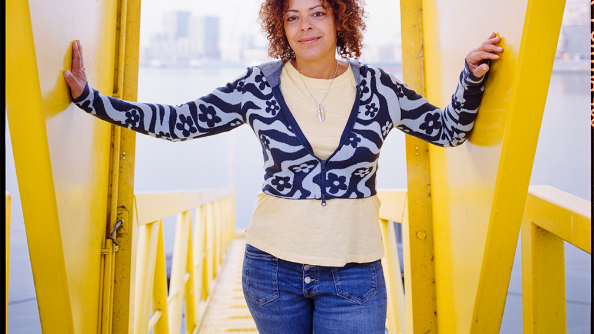 Nina Jurna staat op een gele steiger aan het water