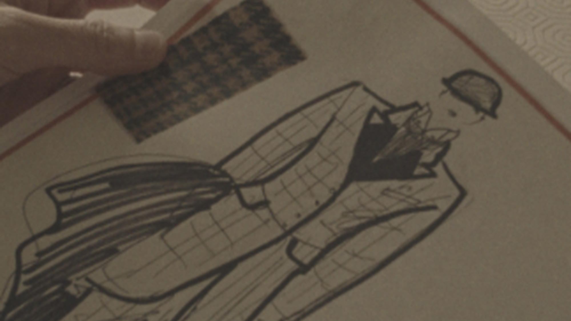 Een hand houdt een modeschets vast.