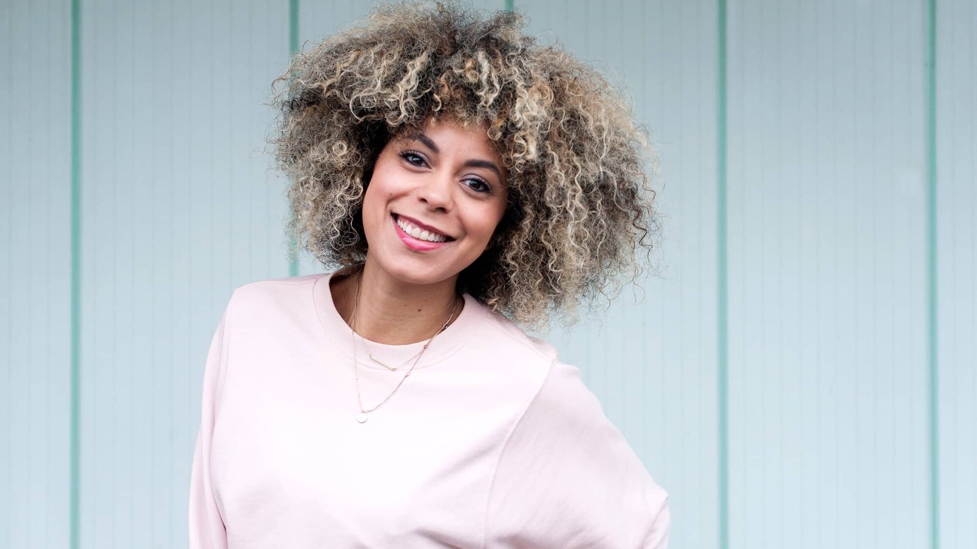 Presentatrice Noa Johannes kijkt lachend de camera in.