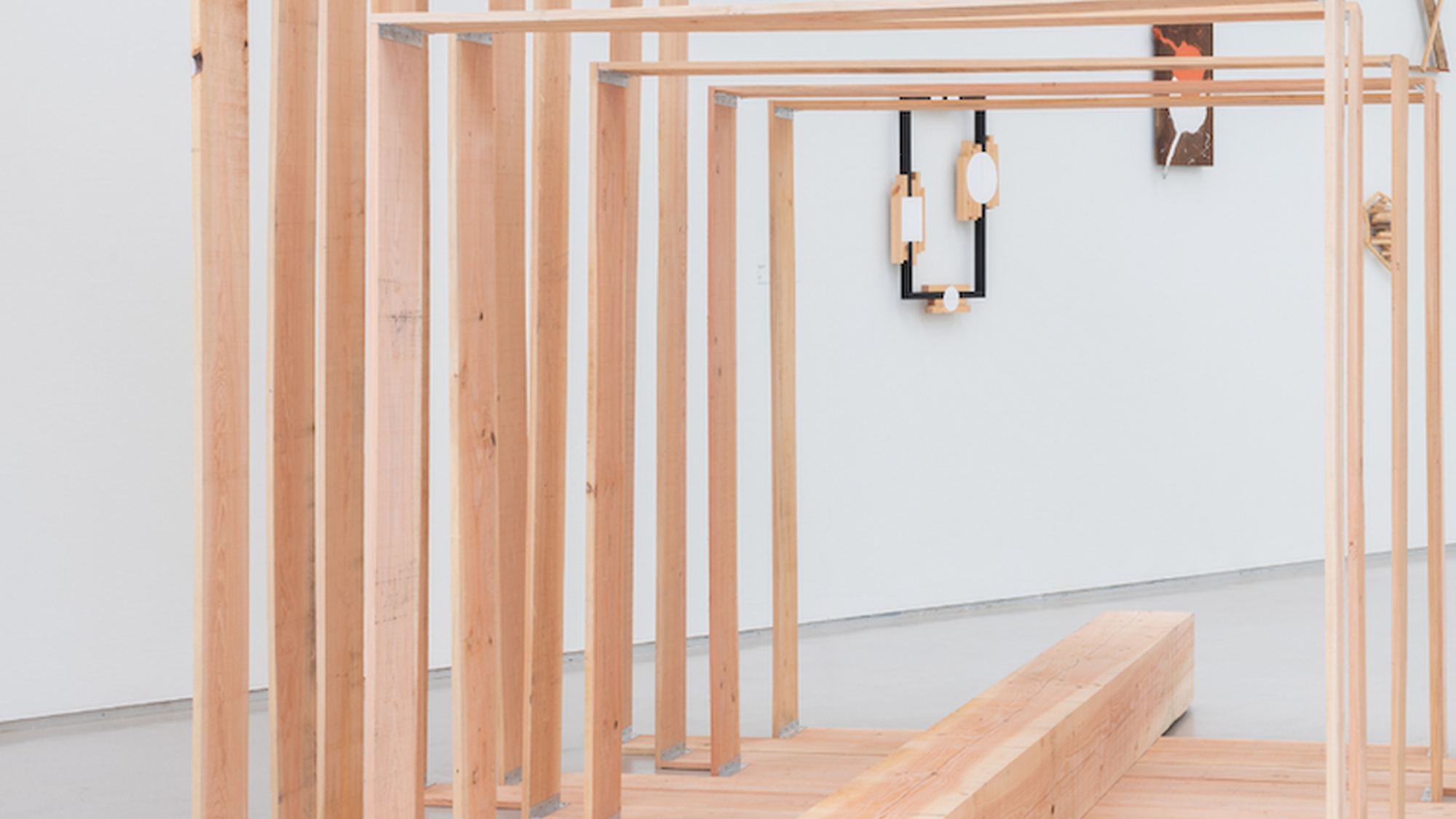 Kunstwerk van Kishio Suga; houten frames met een houten balk in het midden.