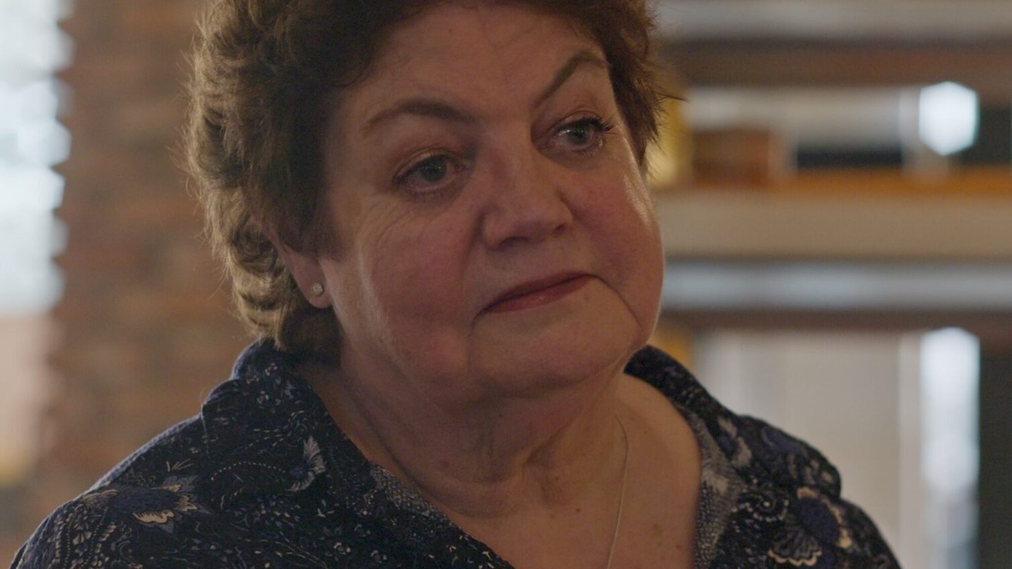 Een mevrouw uit de documentaire 'Dit hoort bij ons' kijkt moedeloos voor zich uit.