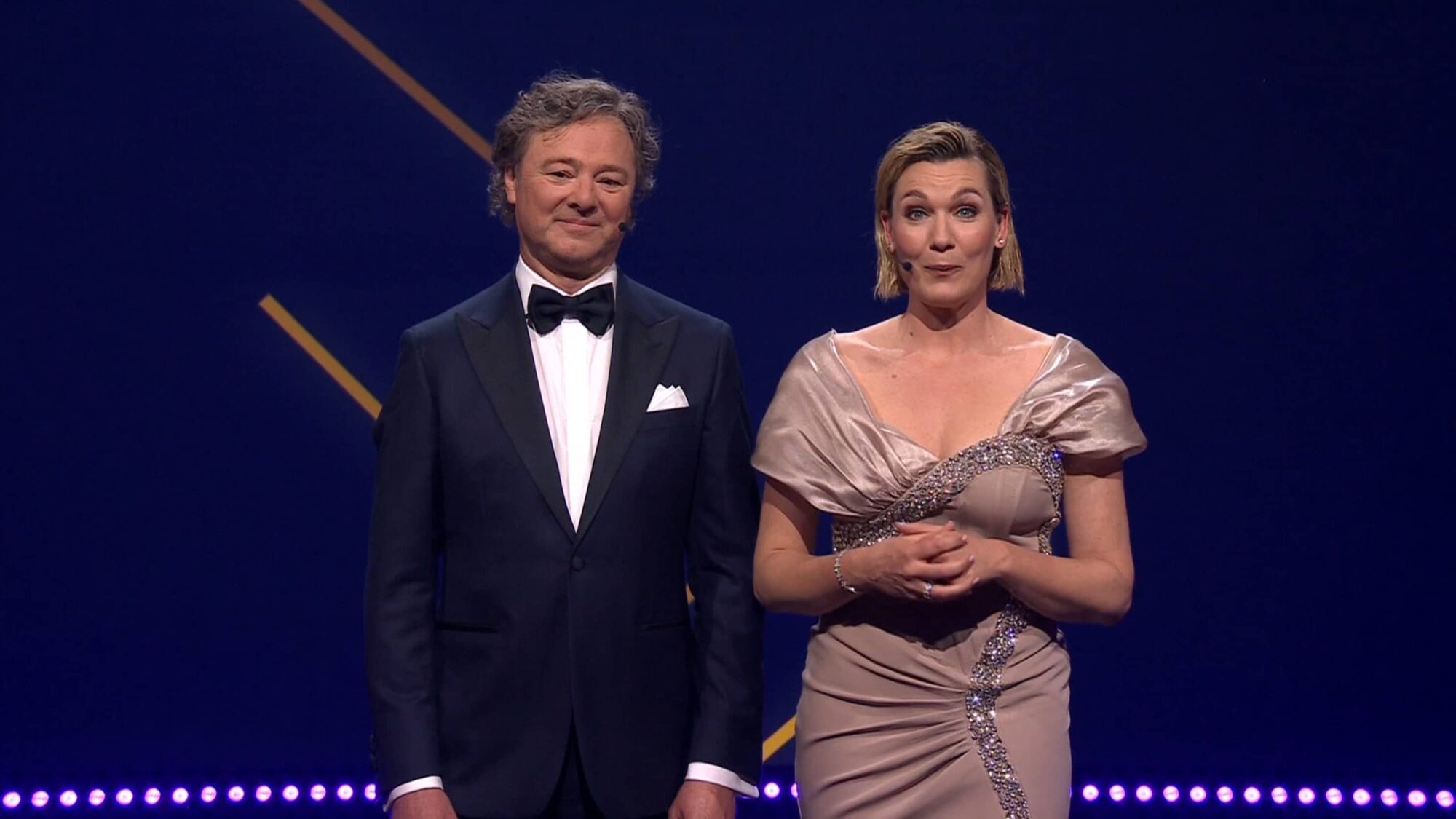 Presentatoren kijken in de camera terwijl ze de awards presenteren