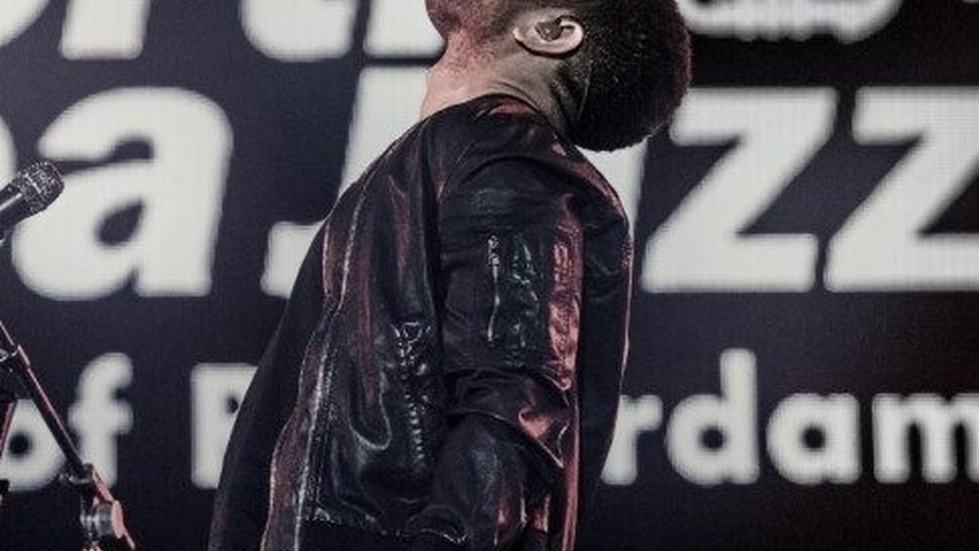 Zanger leunt tijdens het zingen naar achteren op het podium van het North Sea Jazz festival.