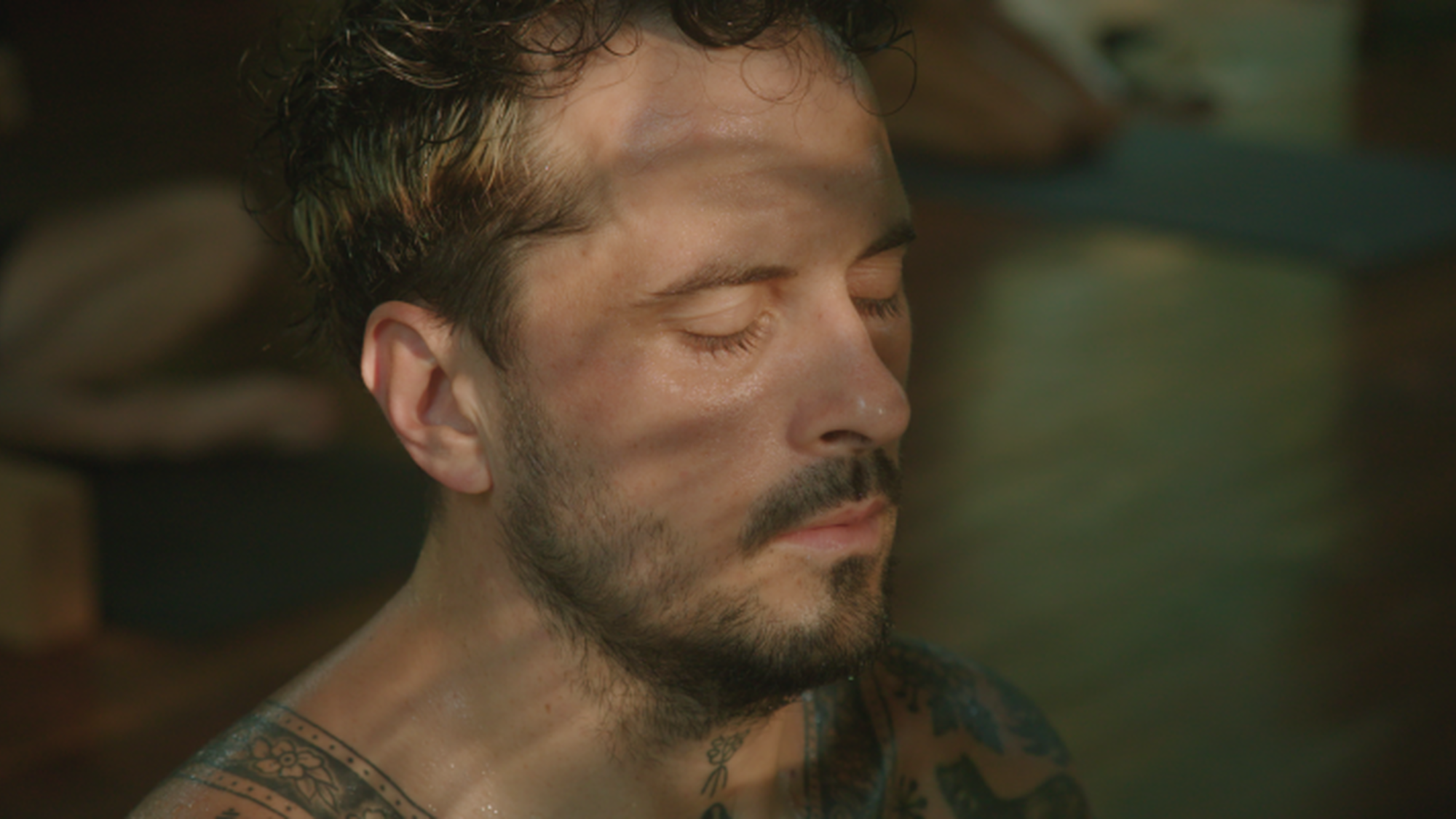 Zwangere Guy doet yoga, heeft zijn ogen gesloten