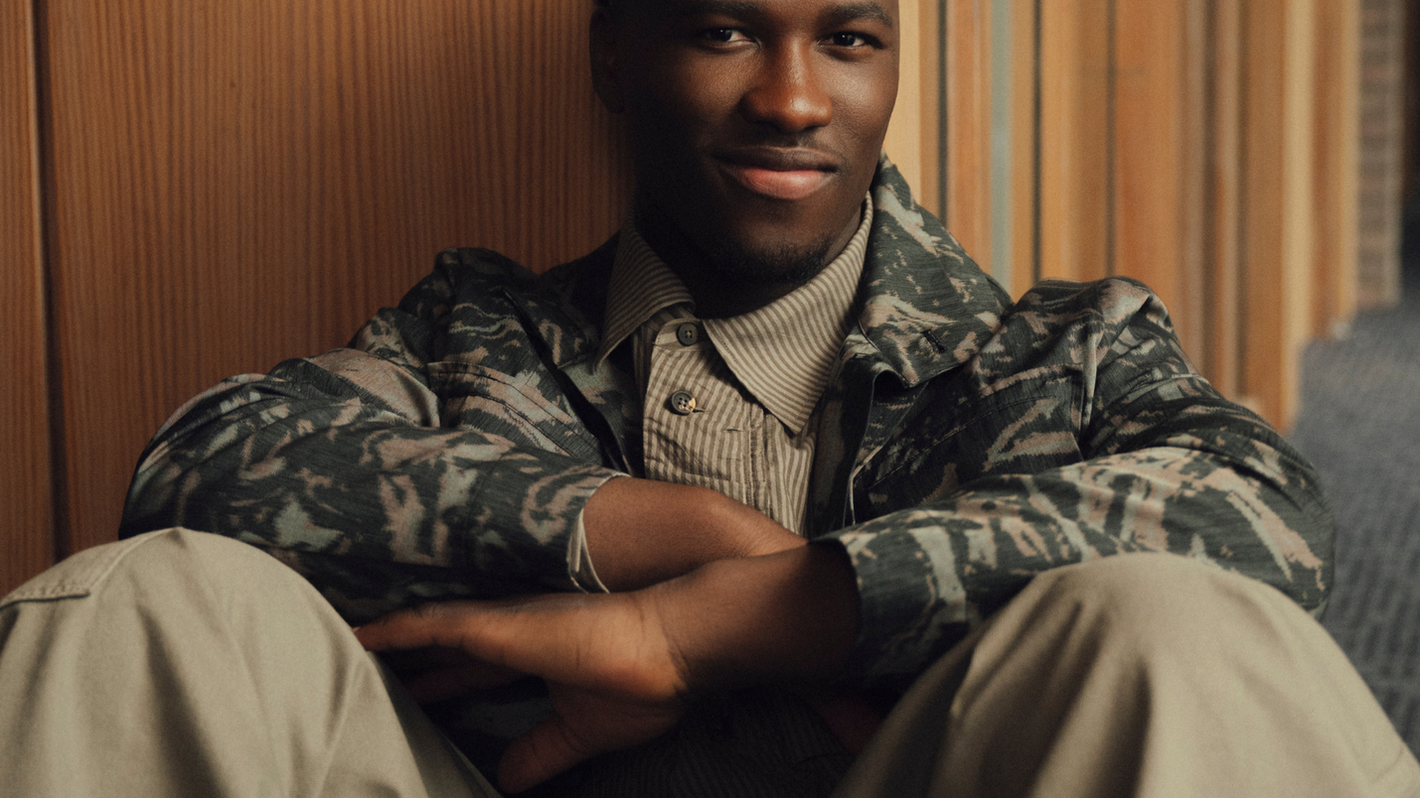 Foto van zanger Claude, die achterover geleund tegen de muur zit