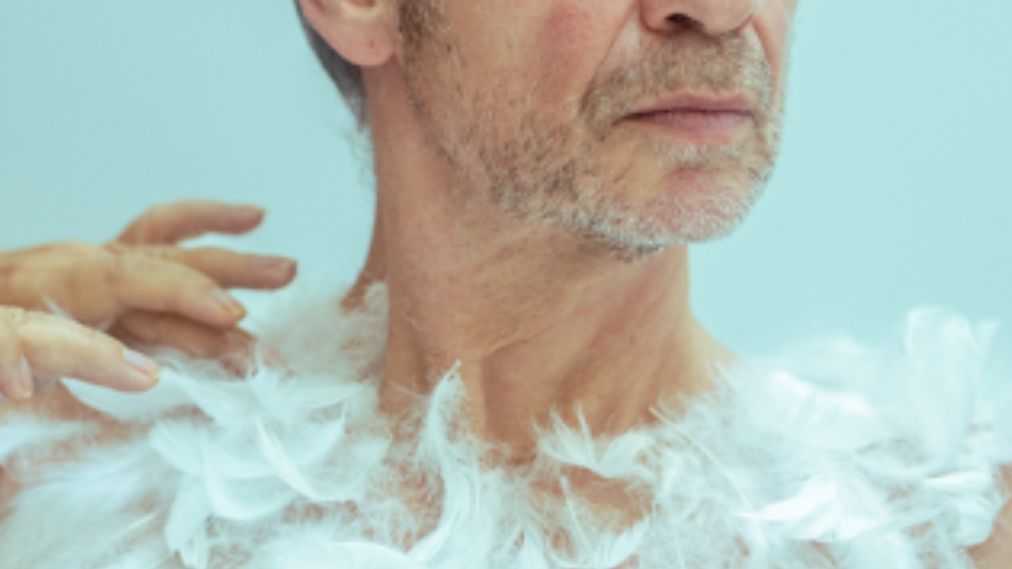 Hier is een man te zien met een ontbloot bovenlichaam met veren er op geplakt.