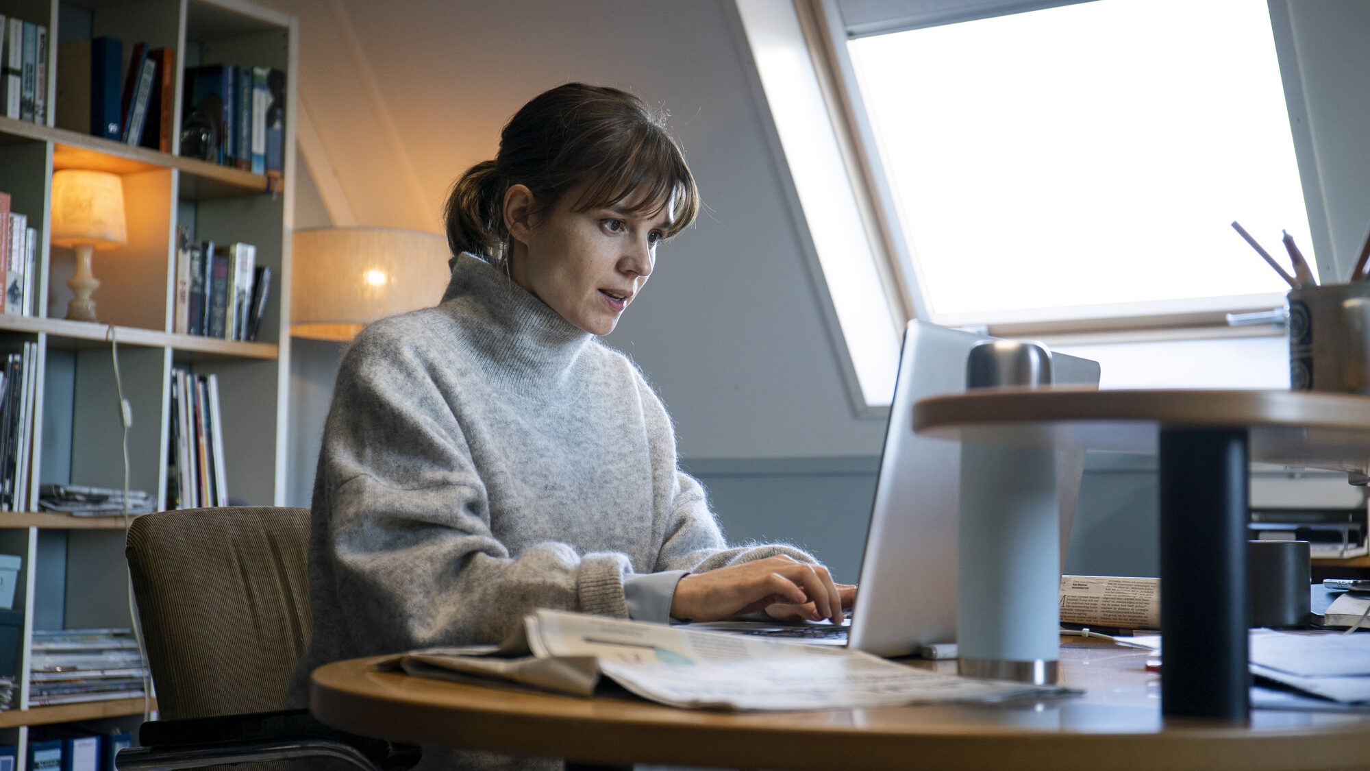 Vrouw zit achter laptop in een werkkamer