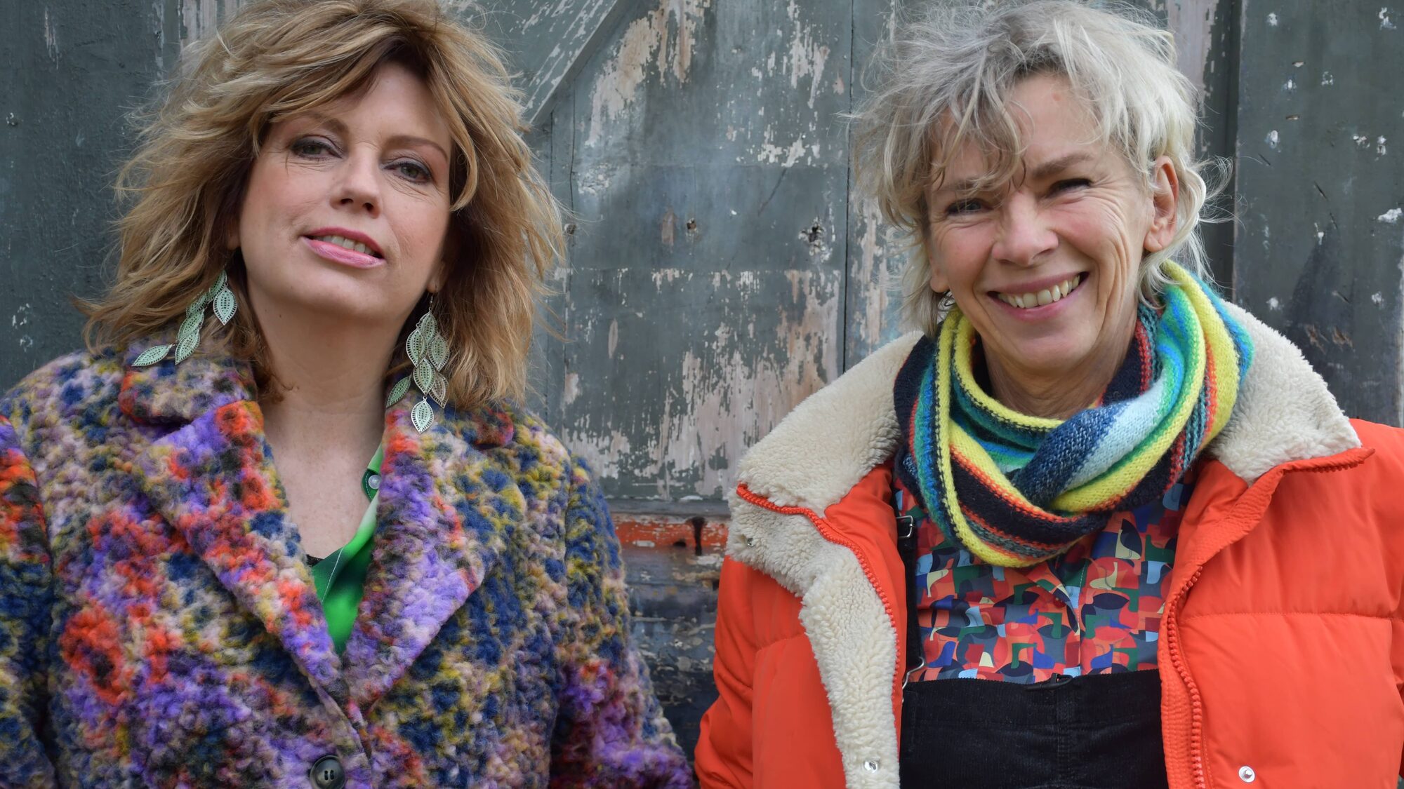 Twee vrouwen staan lachend naar de camera