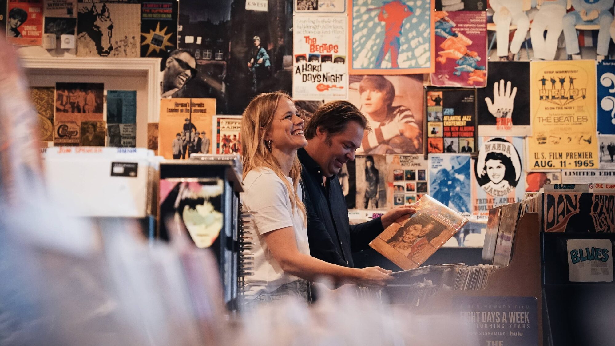Ilse DeLange en Frank Evenblij bekijken platen in een platenzaak.